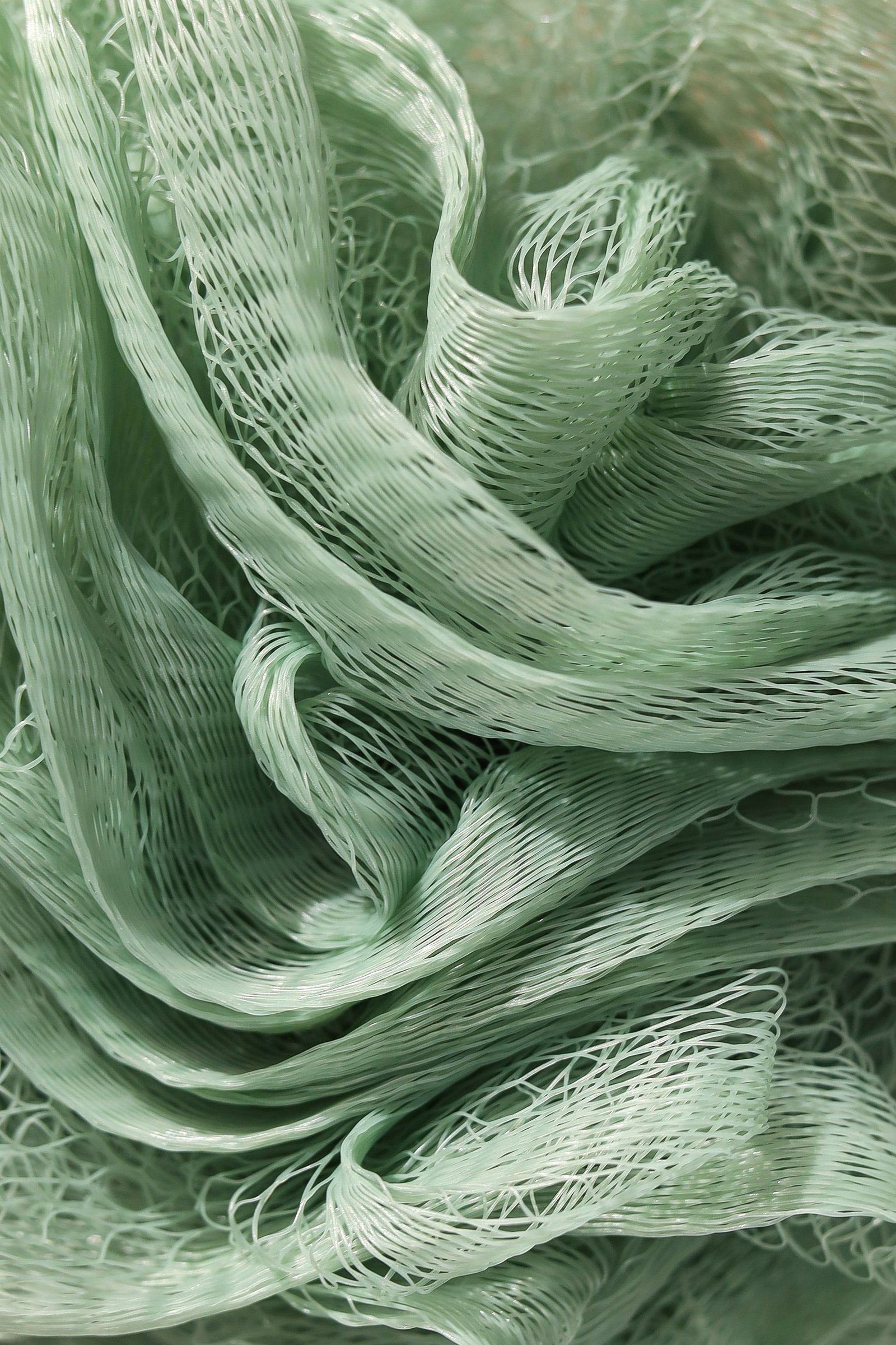 Gathered green open-weave shade mesh.