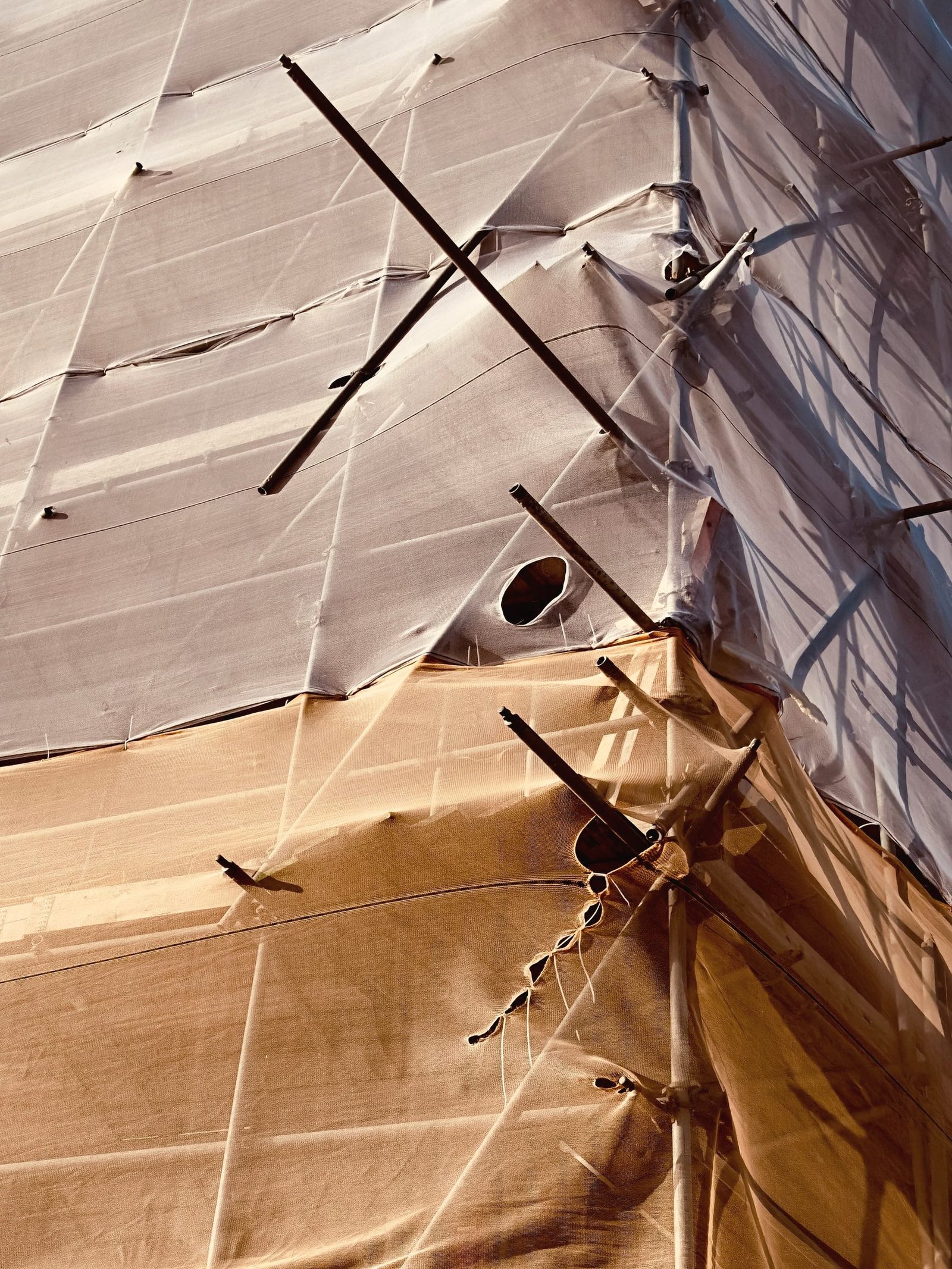 A taut fabric canopy stretched over a timber frame.